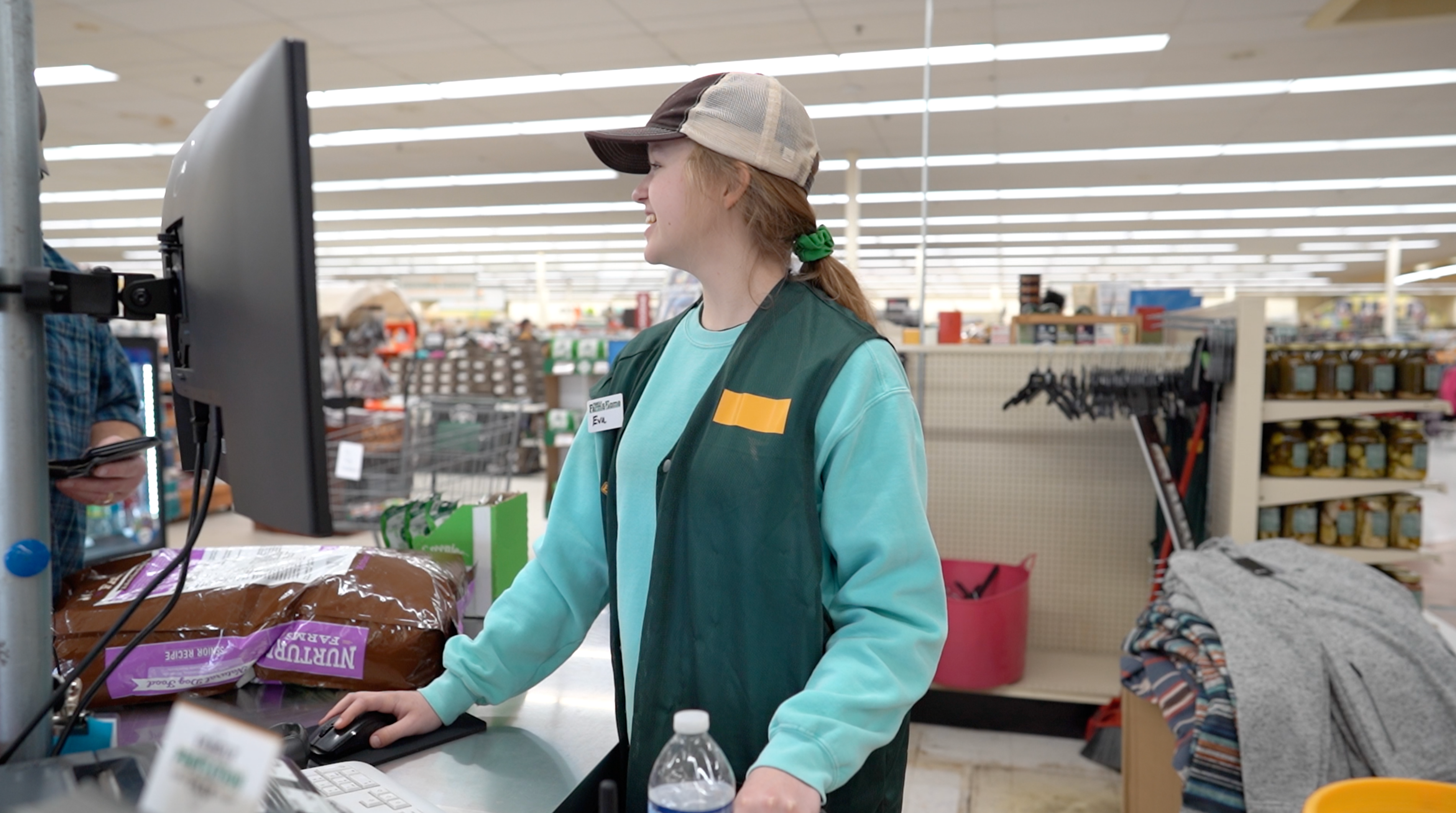 cashier smiling while helping a customer checkout